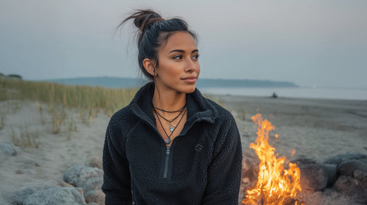 Women’s Sherpa Pullover – Cozy 1/4 Zip Fleece in Black Woman sitting by a campfire on a beach
