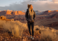 Women's Puffer Jacket in Black – Lightweight Adventure Coat Person standing in a desert landscape with mountains in the background