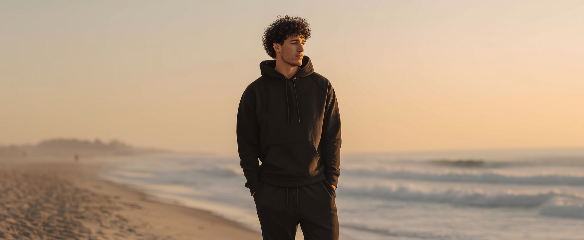 Man standing on a beach at sunset